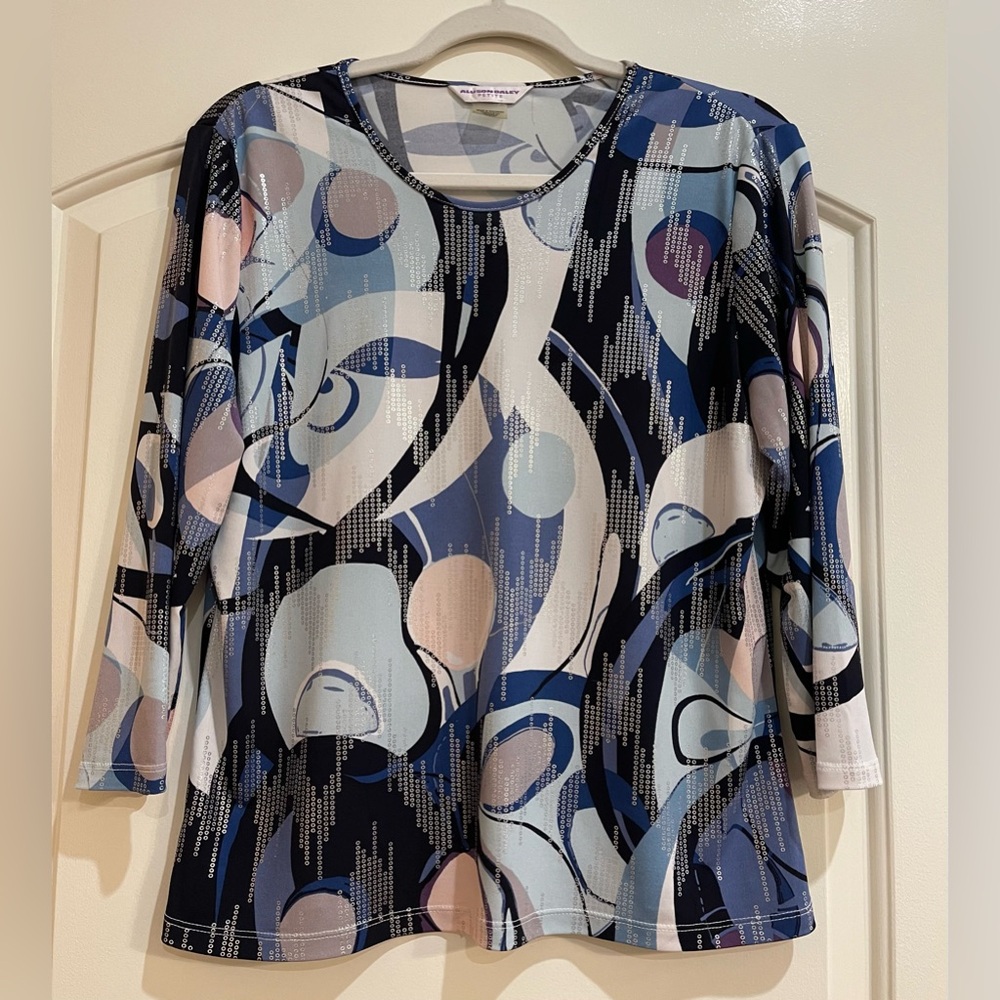 Allison Daley pullover top. Colors in black, blues, peach, purple with silver.